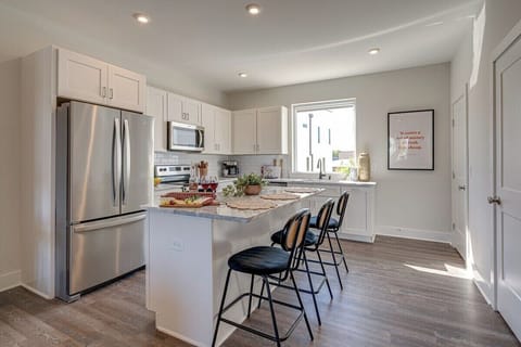Open kitchen with stainless steel appliances, large island, breakfast bar seating, and is fully equipped with your basic cooking essentials.