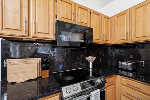 The black top compliments with the wood theme fixtures in the kitchen.