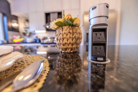 This space features modern amenities and thoughtful touches, like a retractable power tower for all your charging needs, set on a stunning granite countertop.