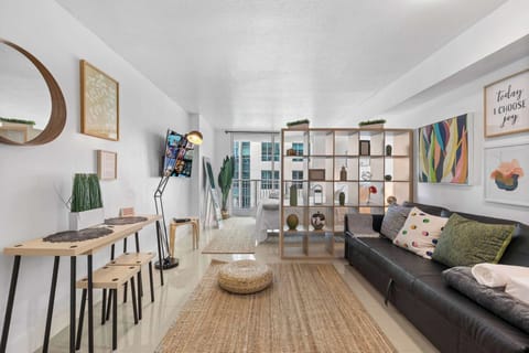 A full view of the modern studio with its cozy Queen bed, practical desk, sofa bed, and decorative touches that create a welcoming atmosphere. Everything you need in one thoughtfully designed space.