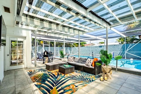 Relax in the tropical outdoor lounge with a cozy seating area, BBQ grill, and poolside fun. Perfect for your Miami getaway!