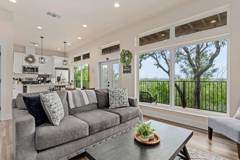 Bright and cozy living room with beautiful tree-lined views! This inviting space features plush seating, a large smart TV, and stylish decor—perfect for relaxing after a day exploring Gruene. Floor-to-ceiling windows bring the outdoors in!