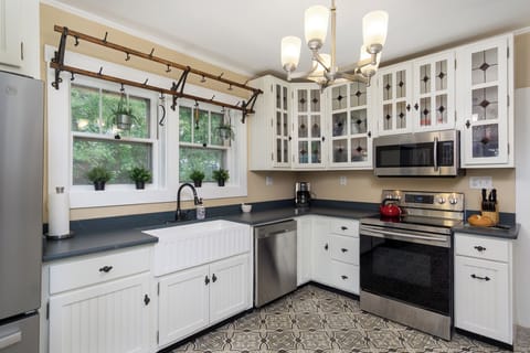 Prepare meals in the fully equipped kitchen, boasting stainless steel appliances and a large farmhouse sink.