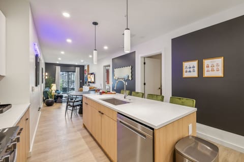 Fully equipped modern kitchen stocked with all culinary essentials and featuring brand new stainless steel appliances with an island offering bar seating.