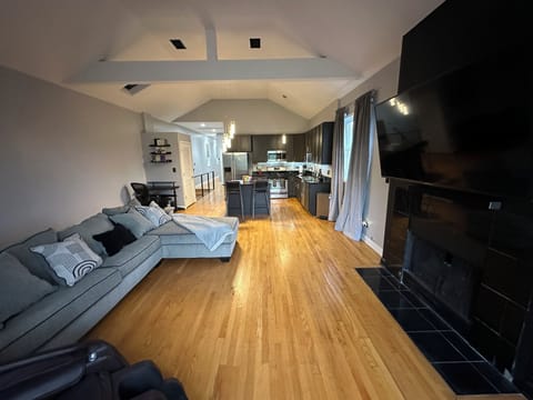Open living room features vaulted ceilings and hardwood floors. 