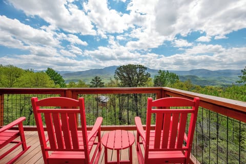 Relax in these vibrant red chairs on your private deck, where sweeping mountain vistas stretch endlessly before you.