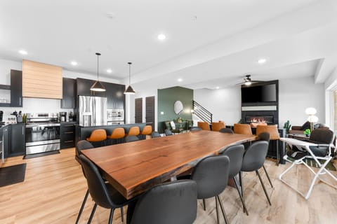 Gather around the custom live-edge table that comfortably seats 12—ideal for big meals, birthdays, or laid-back evenings. Additional bar seating nearby adds flexibility.