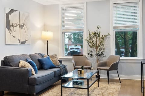 Sunlit living room w/ comfortable seating & simple, modern decor