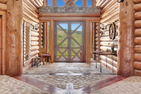 Grand entrance with timber columns and authentic log architecture