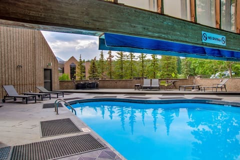 Resort pool deck with mountain backdrop.