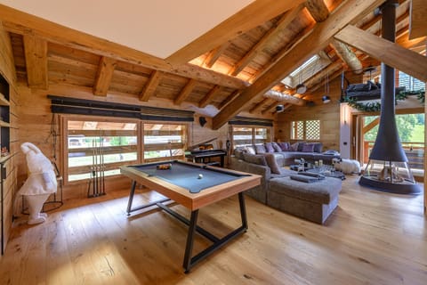 Lounge area with custom-made sofa and central fireplace ideal for warming up by the fire after a day on the slopes