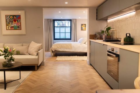 Spacious open-concept kitchen and living area with a view into the cozy bedroom, perfect for a seamless and comfortable stay.