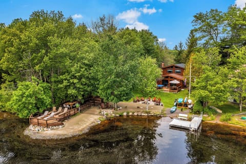 This inviting lakefront scene at Mohawk Chalet showcases a spacious dock, lounge deck, and fire pit area—perfect for swimming, sunbathing, and making memories by the water.