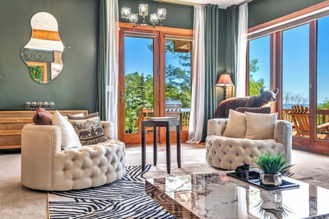 Beautiful view from the glass windows and decks outside. Primary Living Room with Smart TV, entrance on to deck, open concept with the kitchen, bathroom, and hot tub room. 