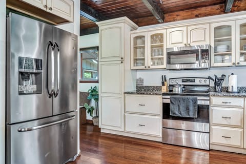 The kitchen features sleek, modern appliances, including a French door refrigerator, microwave, dishwasher, stove, and more, making it a chef's dream.