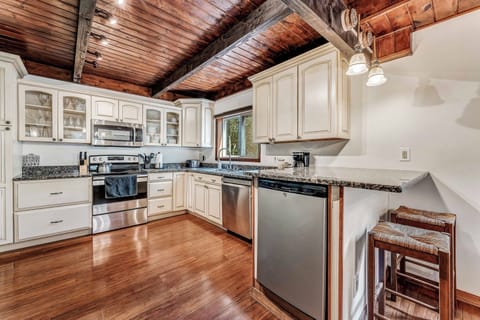 The kitchen features sleek, modern appliances, including a French door refrigerator, microwave, dishwasher, stove, and more, making it a chef's dream.