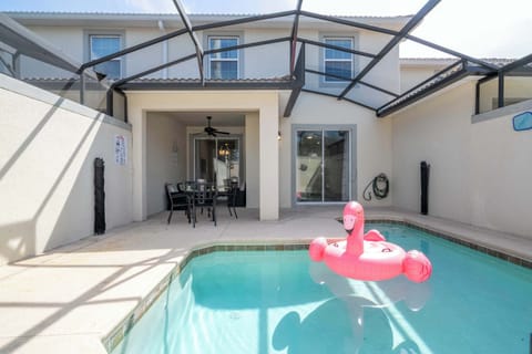 Dive into relaxation in your own private screened pool, complete with a fun flamingo float and cozy patio seating – perfect for sun-soaked afternoons in a modern, airy space.