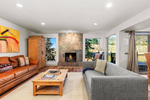 Sink into plush seating by your crackling fireplace, where mountain light streams through expansive windows and inviting warmth welcomes you home after every adventure.