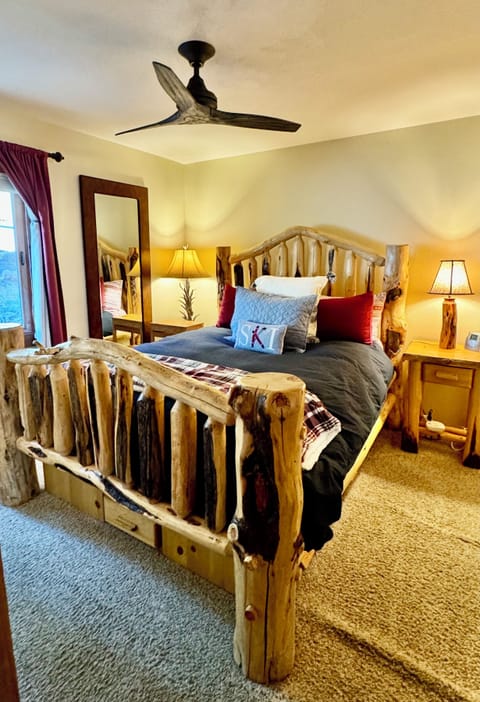Queen bed in the bedroom with large log woodframe.