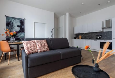Stylish lounge inside a studio appartement Tilburg, combining a cozy sofa, elegant chairs, and round black tables. With vibrant greenery and warm decor, it’s perfect for Bed en Koffie near Tilburg Centrum. A relaxed ambiance for University overnachten or Safaripark Beeksebergen overnachten – a goedkoop stay with seamless flow into the dining area.