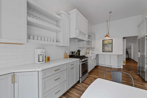 Welcome to a culinary sanctuary where serenity meets sophistication - a vision of pristine white cabinets and classic wood floors that beckon you to savor every moment in this stunning kitchen.