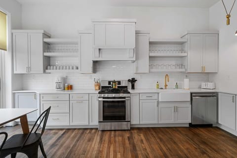 Feel the rustic charm of this kitchen with its white cabinets and inviting wood floors, making every meal a deliciously memorable experience.