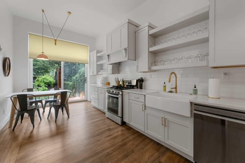 Feel the rustic charm of this kitchen with its white cabinets and inviting wood floors, making every meal a deliciously memorable experience.