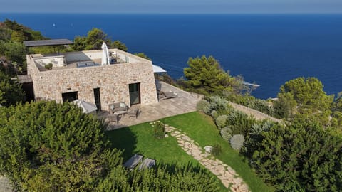 Aerial view of Villa Sognoblu with stone design, terraces, gardens and sea view.