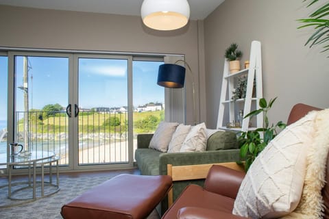 Living area with sofa, arm chair and coffee table. Sea views