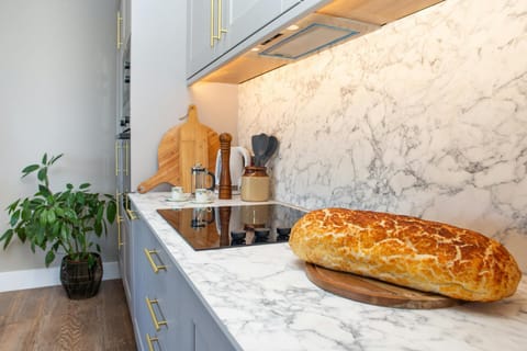 Kitchen area with marble effect worktop and splash back. Electric hob
