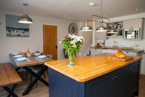 Dining table laid for dinner with a bench and three chairs