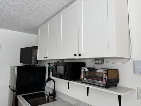 Queen bed, dining area, kitchenette with fridge, cooktop, microwave, toaster.