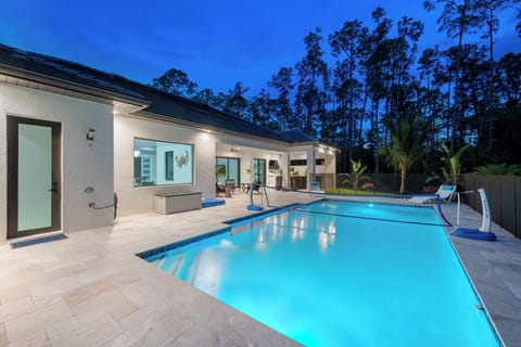 Heated saltwater pool, perfect for relaxing under the stars.  Volleyball net in pool -Surrounded by lush greenery, this private oasis promises a serene and luxurious getaway.