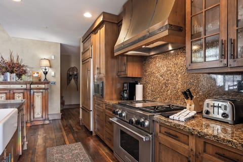 - Embrace warmth in a kitchen where granite counters meet rich wooden cabinetry
- Modern stainless appliances pair beautifully with cozy, classic lodge details
- Decorative vintage touches and a soft rug add charm to every step