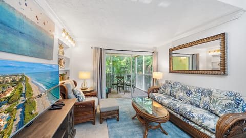 Relax in the beautifully decorated living room, featuring coastal decor, a large Smart TV for streaming, and easy access to your private screened lanai in Longboat Key.