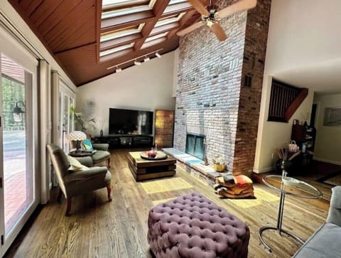 double ceiling height Living rm w/ skylights, 85"TV and wood burning fireplace