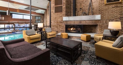 Unwind by the glowing fireplace in a cozy lounge setting.
