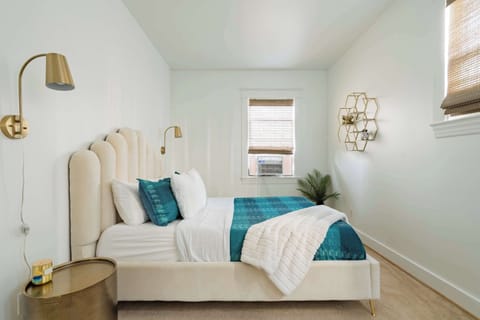 Bedroom 1 with queen bed and wall sconces.