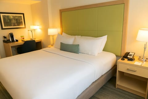 Sink into plush pillows under warm, calming bedside light.