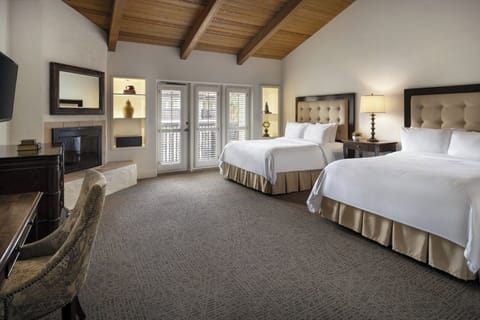 Stretch out in a spacious double-queen room with warm lighting.