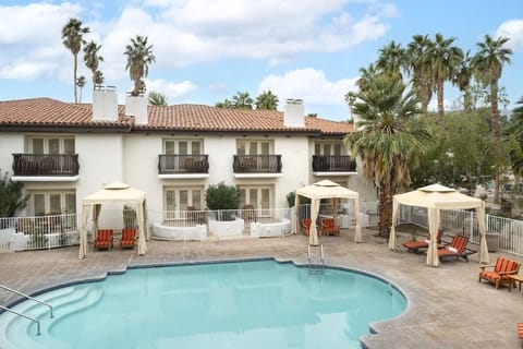 Lounge poolside with shaded cabanas and bright morning skies.
