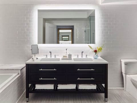 Get ready effortlessly with a double vanity and glowing mirror.