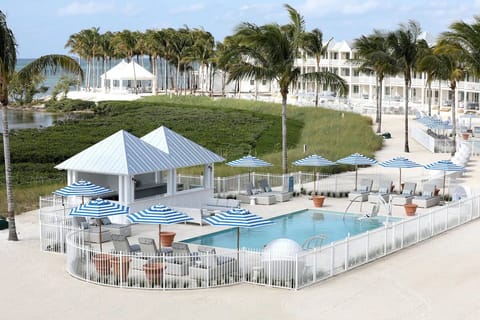 Gather poolside under striped umbrellas for effortless relaxation.