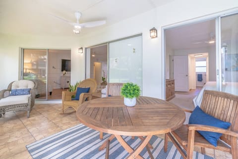 Lanai with teak wood table and chairs, rocking chair, lounge chair with chaise