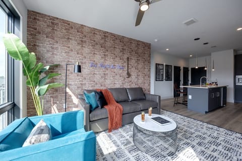 Unit 2: Bright open concept living area with floor to ceiling windows providing panoramic views of Midtown! Features designer furniture and smart TV!