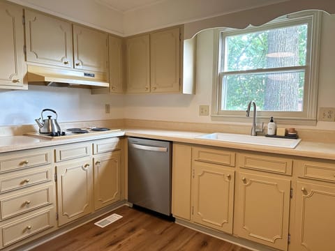 Kitchen stocked with plenty of dishes for four and essentials.