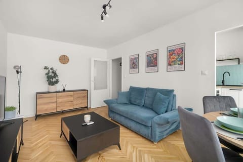 Living room with dining table and blue sofa.