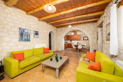 Open-plan living room with sofas, dining area, kitchen, ornamental fireplace, A/C, WiFi internet, and satellite TV