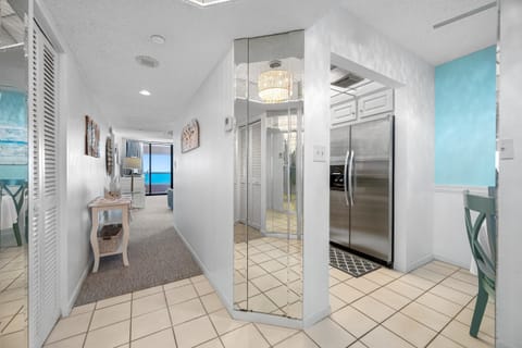 Bright tiled foyer with view and coastal charm.