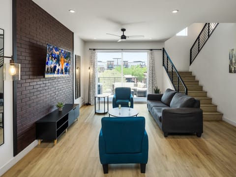 1st Floor: Warm and inviting living room featuring a Smart TV for entertainment, and designer furnishings including a sleeper sofa that converts into a Queen Bed.